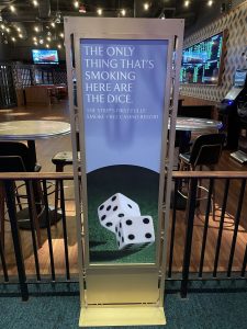 Signage at the entrance of the gaming area of the Park M-G-M Casino in Las Vegas promotes the new non-smoking policy with text that reads "the only thing that's smoking here are the dice".