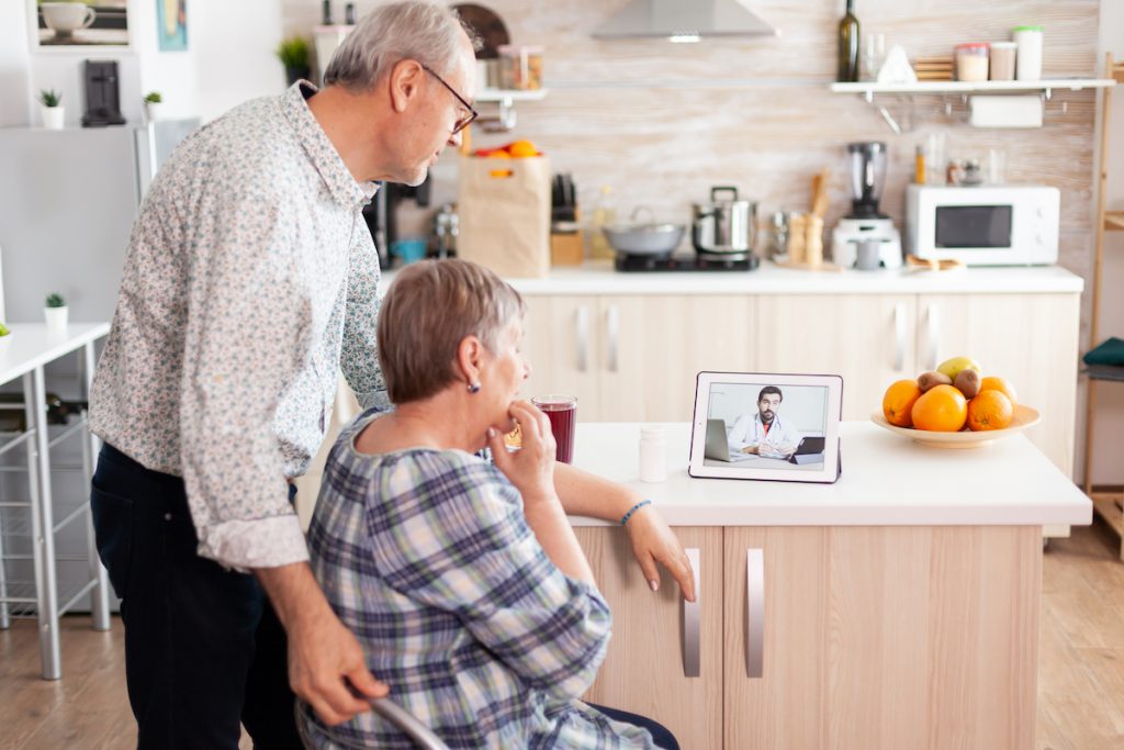 Seniors using a medical app on a tablet to talk with a doctor