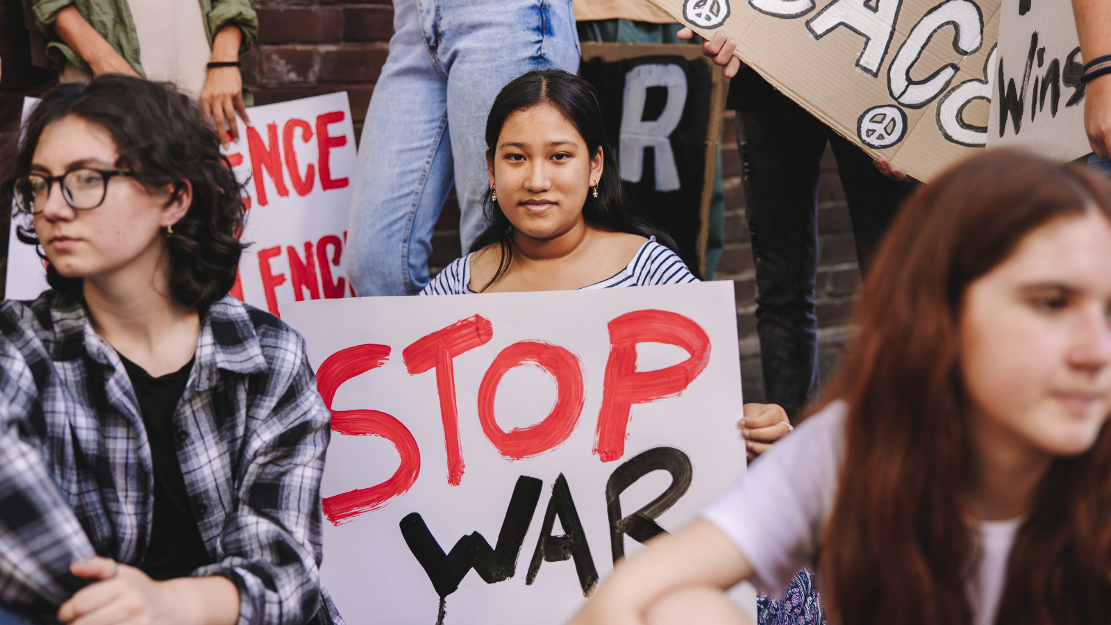 Student holds "stop war" sign at protest