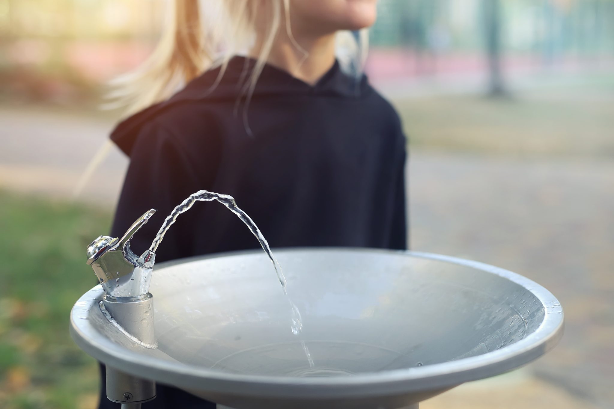 School child at a water fountain