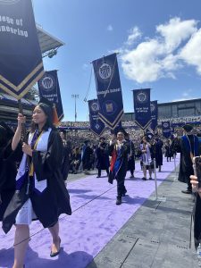 Vince Da carries the UW Graduate School banner as the elected Gonfaloniere at the 2025 commencement ceremony